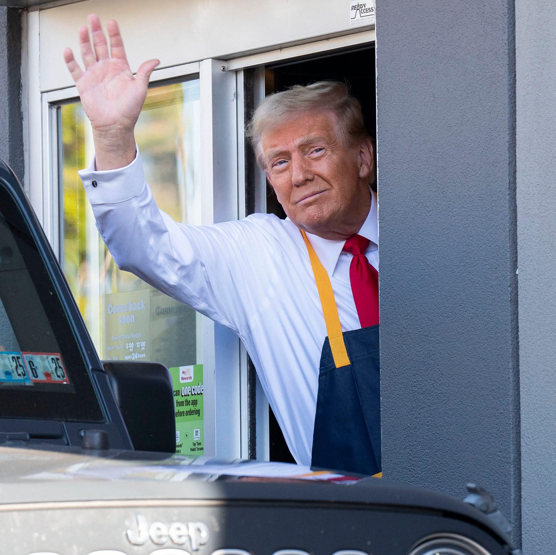 President Donald Trump leaning out of a McDonald's drive-thru window as part of a photo-op during his presidential campaign.